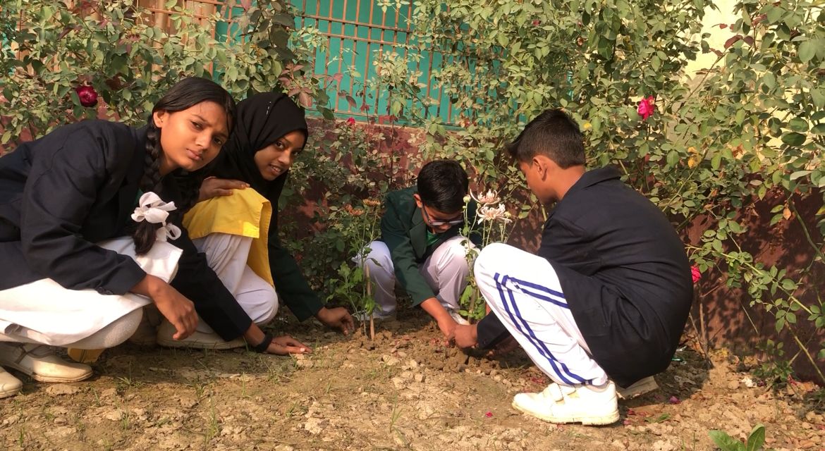 Teacher conducting a class outdoors under a tree